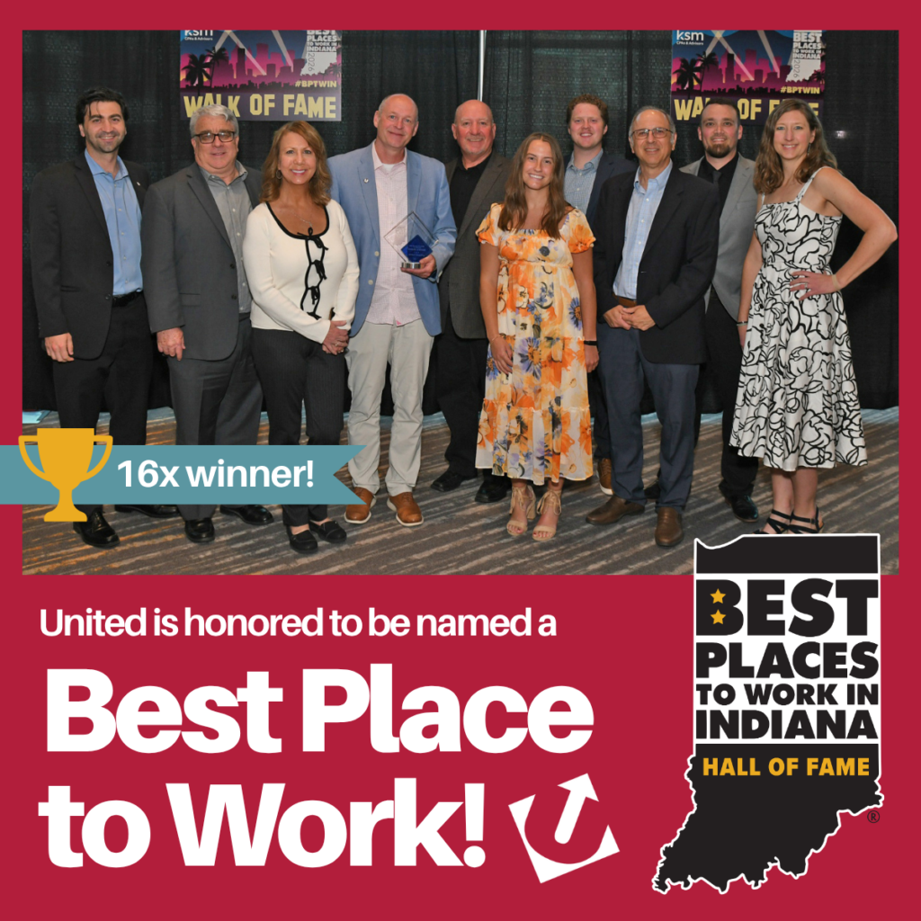 Group of ten adults at an awards event posing for a photo with a blue ribbon banner reading '16x winner' and a Best Places to Work in Indiana backdrop and logo in the corner.